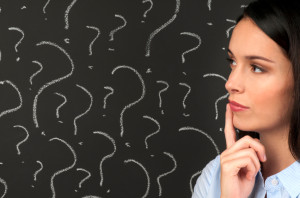 Woman contemplating question marks